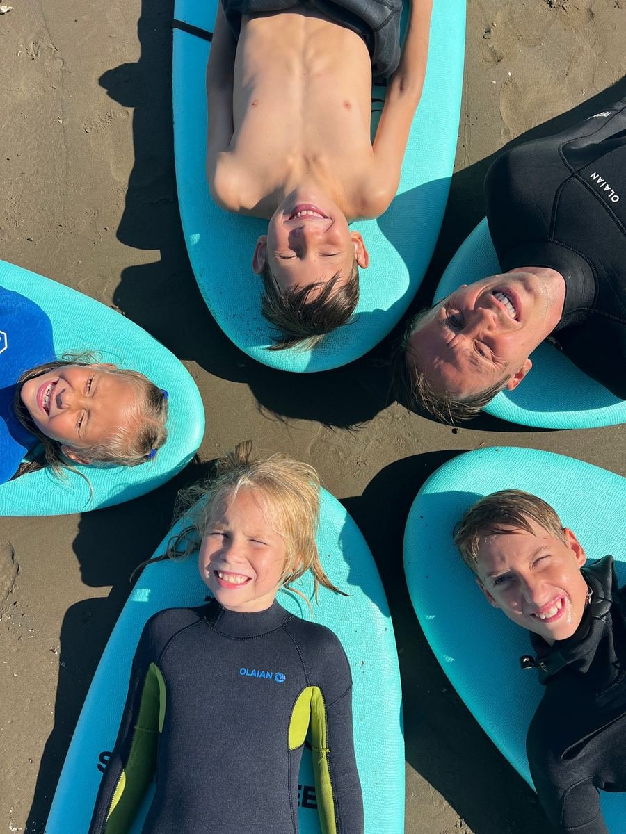 Students and instructor resting on surfboards after a lesson